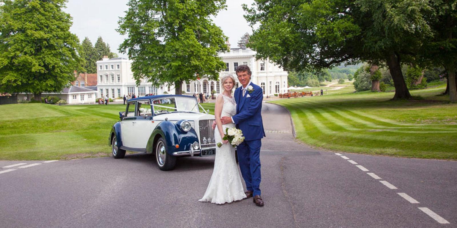 Burhill wedding couple on driveway with car