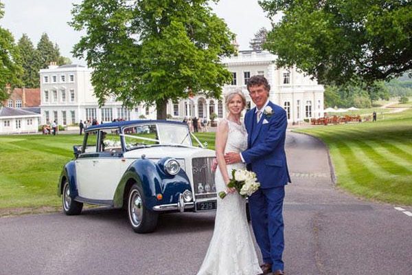 Burhill wedding couple in front of clubhouse with vintage car